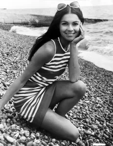00197 Prints: Virginia North Model posing on the beach in a striped dress resting her chin