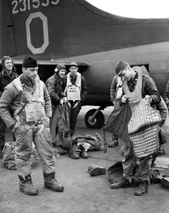 Usaaf Prints: A waist gunner of the American Eighth Army Air Force preparing his armour plated jacket