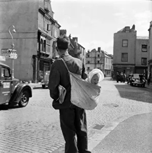 00021 Prints: Bill Ward delivering papers and carrying baby grand daughter Jennifer Howbley