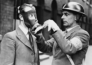 01251 Prints: A warden fitting context masking tape to a civilian air respirator commonly known as a