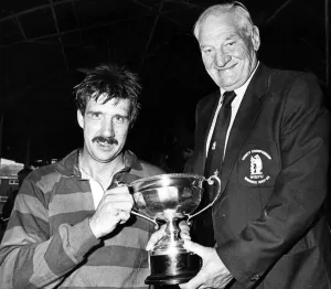 Warwickshire RFU President Harry Walker presents the Country Championship trophy to