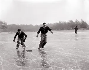 Weather Winter Scenes 1954 Two boys playing ice hockey on a frozen lake in winter