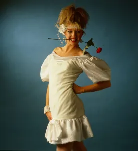 Wedding dress fashion, June 1986 model wearing white mini dress with rose flower in