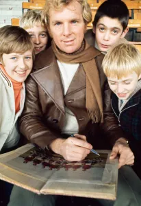 West Ham United footballer Bobby Moore modelling a leather coat with scarf February