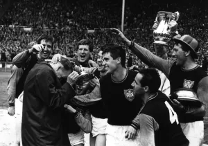 West Ham United mob their manager Ron Greenwood after they had won the FA Cup in 1964