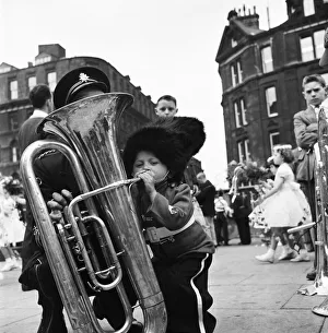 Whit Friday Prints: Whit Walks Manchester: Patrick Rooney aged 4 tries his hand at a big blow