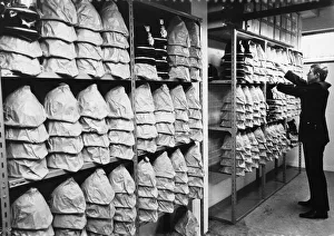 01502 Prints: A wide selection of different sized helmets at the Mid Anglia police Headquarters, 1973