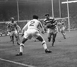 Wigan centre Davies, grits his teeth as he approaches the waiting Greenwood of Wakefield