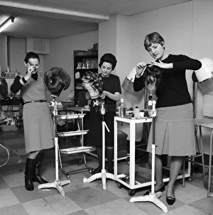 Wigmakers Workshop: Women making wigs whilst in another part of the workshop hair is