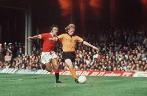 Willie Carr of Wolves with Lou Macari of Manchester United chasing him