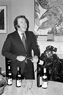 Wine: Mr. David Frost trying to open a bottle of wine at his home