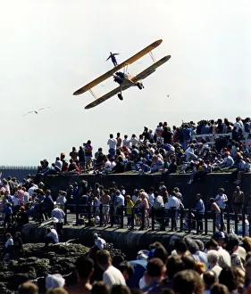 Aerobatics Prints: A wing walker performs on the Cadburys Crunchie Boeing-Stearman Model 75 biplane