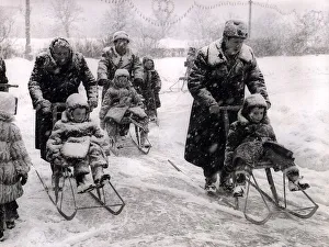 Sleighs Prints: Winter Russian style with adults pushing children in chair sledges while being well