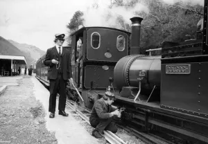 A woker applying some oil to one of the steam trains on the Talyllyn railway line which