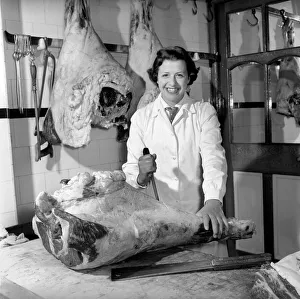 Woman butcher seen here at work. 1954