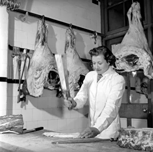 Woman butcher seen here at work. 1954