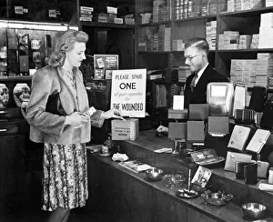 A woman buying a packet of cigarettes in a tobacconist shopin London