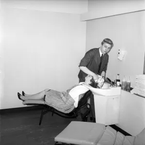 Woman having her hair washed at the John London Hair and Beauty Saloon. 1960
