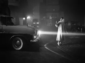 Darkness Prints: A woman helping to direct traffic through the thick fog in Central London