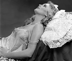 Nightie Prints: Woman leaning back against a lace pillow wearing a silk nightdress March 1980