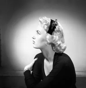 00068 Prints: Woman modelling the latest 1956 hat fashions in the Reveille studios. June 1956