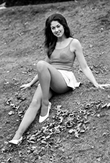 Woman posing outdoors wearing a short white skirt and vest top