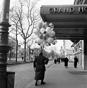Austria Prints: A woman selling balloons in Vienna. For hours the old lady of Vienna had tramped the cold