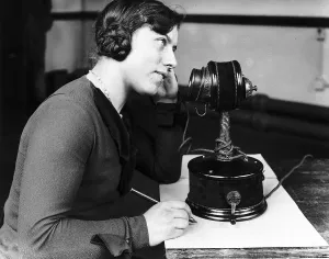 Core39 Prints: Woman using early telephone. Large candlestick phone Circa 1920