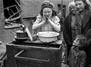 A woman washes her faces surrounded by bomb damage on St