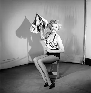 Woman wearing bra and skirt holding parasol. 1959