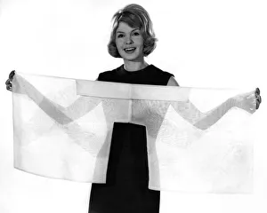 00038 Prints: Woman wearing a clack sleeveless dress holding a see through scarf
