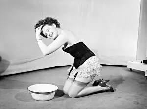 Woman wearing corsett washing hair. 1959