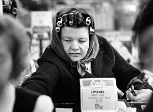 A woman wearing curlers in her hair enjoying shopping in the sales after Christmas