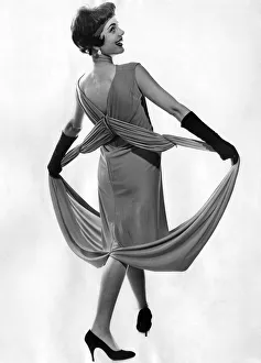 Woman wearing a long sleveless dress with black gloves and high heel shoes