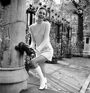 Woman wearing matching top, mini skirt and knee high looks poses for pictures