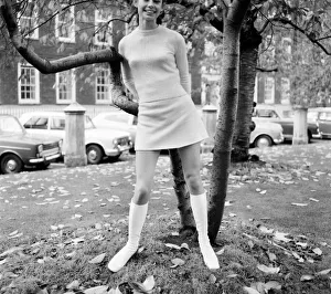 Woman wearing matching top, mini skirt and knee high looks poses for pictures