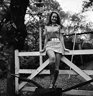 Woman wearing mini dress with belt across the waist and knee high boots