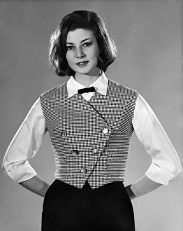 Woman wearing white blouse, black skirt and waistcoat. Reveille Fashions. Pamela March