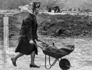 00026 Prints: Woman wheeling a wheelbarrow filled with a sack of coal at Bentley Lane in Walsall