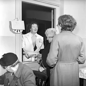 Women chat, share a cup of tea and read the newspapers at a womens lodging house