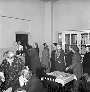 Women chat, share a cup of tea and read the newspapers at a womens lodging house