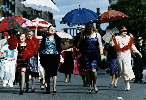 Women dressed as 1920s flapper girls walking down a street during the Edinburgh