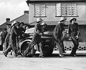 Women fire fighters from Erith Kent walk beside their trailer pump during WW2 1942