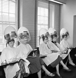 Women at the hairdressers seen here under the driers. April 1956