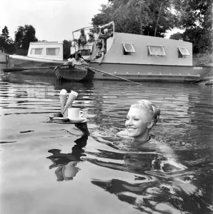 Women: Humour: When she wants refreshments she swims for it Along the quiet banks of