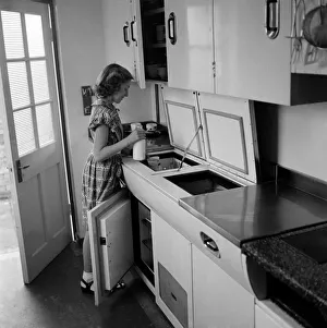Household Prints: Women in her kichen using moden gadgets installed in her home to save on labour