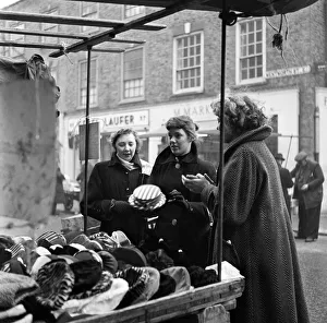 Market Trader Prints: Women out looking for a bargain on the milliner stall at Petticoat Lane Market