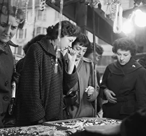 01107 Prints: Women peruse the jewellery on a market stall at an un-named street market in the East End