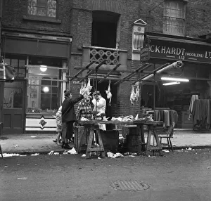 Women peruse kosher chickens at an un-named street market in the East End of London 11th