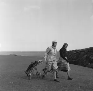 01126 Prints: Women playing a round of golf on a very windy Fort Island Golf links Hotel on the Isle of